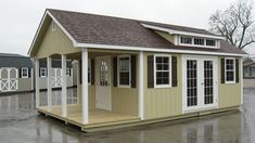 a small house with two windows and a door on the outside, sitting in a parking lot