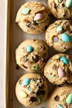 chocolate chip cookies with easter eggs and m & m's in them on a baking sheet