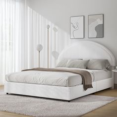 a white bed sitting on top of a wooden floor