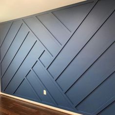 an empty room with blue walls and wood floors