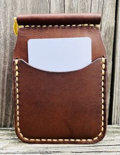 a brown leather wallet with a white card holder in the pocket on a wooden surface