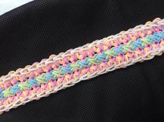 a multicolored braiding on top of a black jacket with white and pink trim