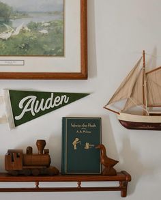 there is a small boat on the shelf next to a book and some other items