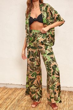 Introducing our Tropical Leaves Print Pull On Pants - the perfect combination of style and comfort. With a wide-leg design and smocked waistband featuring a drawstring, these pants will flatter any body type. The pull on design and side pockets add convenience to the chic tropical print. Unlined for a lightweight feel. Available in multiple sizes and perfect for any occasion. Fabric & fit: 100% polyester Model is wearing size Small.