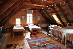 an attic bedroom with two beds and a television in the corner on the far wall