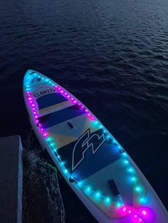 a light up surfboard sitting in the water