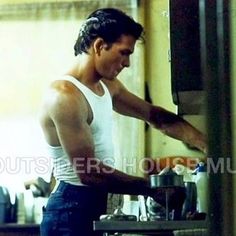 a young man is preparing food in the kitchen