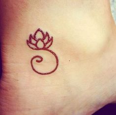 a small tattoo on the ankle of a woman's foot with a red flower