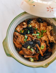 a close up of a bowl of food with rice and vegetables in it on a table