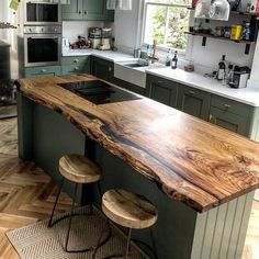 a kitchen with an island made out of wood and two stools in front of it