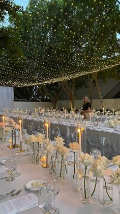 the tables are set with candles and centerpieces for an elegant wedding reception at night