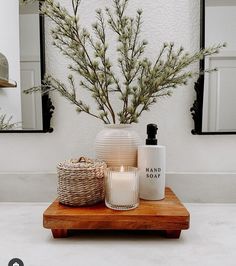 a wooden table topped with candles and vases