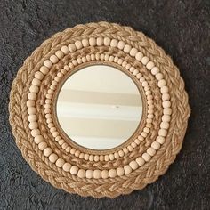 a round mirror with wooden beads on it