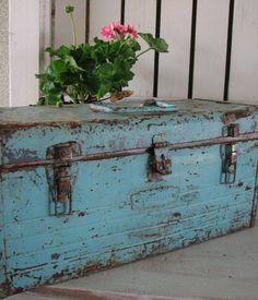 an old blue suitcase with flowers in it