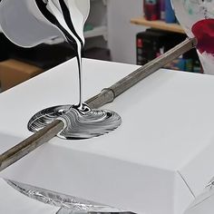 a white box that has some kind of object on it's side and is being poured with liquid