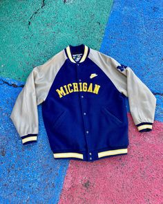 Vintage 90s/Early 2000s University of Michigan Wolverines Varsity Letterman Leather Spellout Bomber Jacket Size XL     You are viewing a VTG Michigan Jacket Nike Team Sports Tag GOOD Condition Minor cosmetic stains on sleeves JACKET WAS DRY CLEANED! FRONT Graphic Body: Wool/Nylon Sleeves: Leather   Measurements: 32" LONG, 23.5" WIDE and 20" Pit-to-Sleeve Terms: Vintage clothing sizing varies and may have minor cosmetic imperfections. We recommend measuring one of your favorite pieces to compare! Will ship as soon as possible AFTER receiving payment. Please ask any questions or request more pictures if you have additional concerns. NO RETURNS, sold as is. Throwback Outdoor Outerwear For Fall, Collegiate Style Track Jacket For Fall Sports Events, Collegiate Long Sleeve Varsity Jacket For Outdoor, Throwback Varsity Jacket For Sports Events In Fall, Throwback Varsity Jacket For Fall Sports Events, Throwback Sports Outerwear With Baseball Collar, Casual Team-colored Track Jacket For Fall, Throwback Fall Varsity Jacket For Sports Events, Throwback Track Jacket For College Sports Season