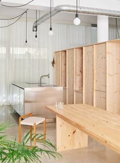 a room with wooden walls and chairs in the center, next to a counter that is made out of plywood planks