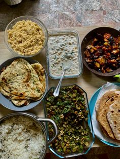 a table topped with lots of different types of food next to bowls and pans