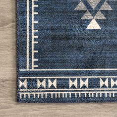 a blue and white rug on top of a wooden floor