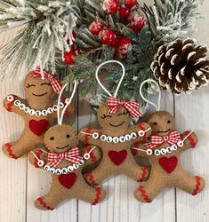 three gingerbread ornaments hanging from a christmas tree