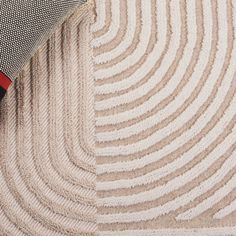 a close up view of the corner of a couch with a red and black pillow