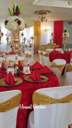 a banquet room with red and gold table cloths, white chairs, and silverware