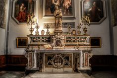 an ornate alter in a church with paintings on the wall