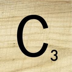 the letter c is made up of wood and has black letters on it's sides