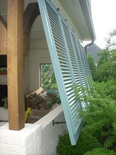 an open window on the side of a house with shutters in front of it