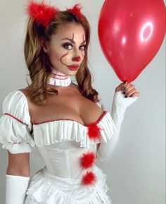 a woman dressed as a clown holding a red balloon