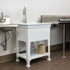 a white sink sitting under a faucet next to a wall mounted soap dispenser