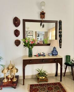 a living room filled with furniture and flowers on top of a table next to a mirror