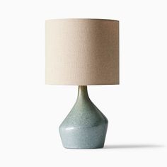 a blue table lamp with a beige shade