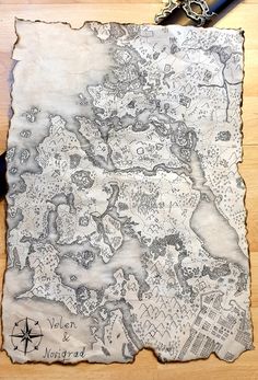 a map drawn on top of a piece of paper next to a pair of scissors