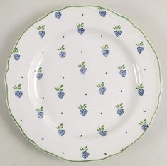 a white plate with blue and green pineapples on the rim, sitting on a table