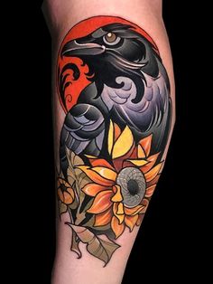 a black bird with sunflowers and leaves on it's leg is shown