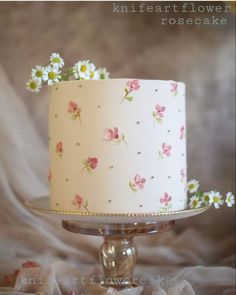 a white cake with pink and yellow flowers on it