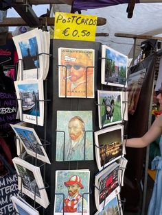 a woman standing next to a display of pictures