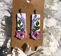 Turn heads with these elegant and timeless polymer clay dangle earrings. Each flower is meticulously handmade ensuring these are one of a kind. These earrings add a splash of elegance and femininity to any outfit. These perfectly enhance the beauty of any bride on her special day. Matching pairs of these on bridesmaids make for a classy sight. You can wear these on a date night with your husband or even in the office. These are versatile making them great for every occasion!  Don't miss out on t Polymer Clay Earrings With 3d Flowers For Gift, Adjustable Polymer Clay Earrings With 3d Flowers, Gift Earrings With 3d Flowers In Polymer Clay, Dangle Flower Earrings In Polymer Clay, Dangle Flower Earrings In Polymer Clay For Gifts, Elegant Purple Polymer Clay Earrings, Purple Polymer Clay Earrings, Matching Pairs, Clay Dangle Earrings