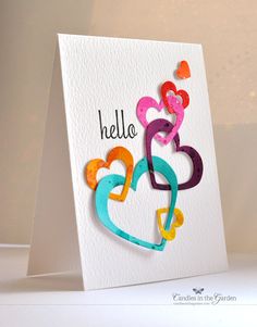 a greeting card with the word hello written on it and hearts cut out of paper