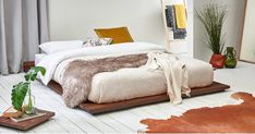 a bedroom with white walls and wooden flooring is decorated in neutral colors, including an animal print rug