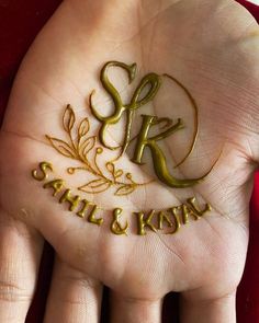 a person's hand with gold lettering on it and the word sr still & koran written in cursive letters