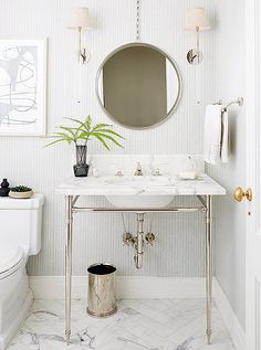 a bathroom with a sink, mirror and toilet in it's centerpieces