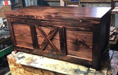 a large wooden box sitting on top of a piece of wood in a workshop area