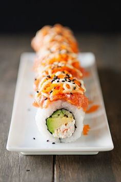 a white plate topped with sushi and cucumber