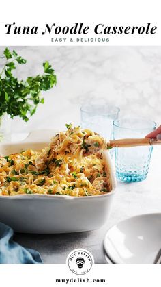 a casserole dish filled with noodles and vegetables in a white baking dish on a table