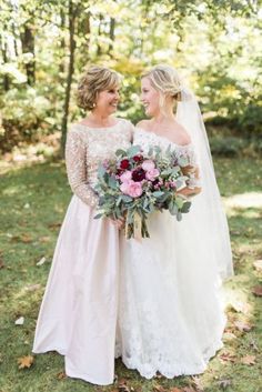 two brides standing together in the woods