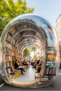 people are sitting on benches and reading books in a large glass ball shaped like a bookcase