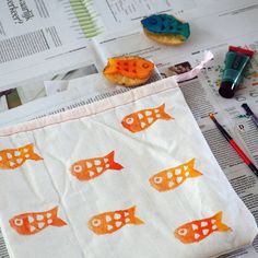 an orange and white bag sitting on top of a table next to some pens and markers