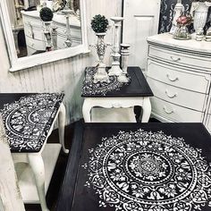 two tables with black and white designs sit in front of a mirror on the wall